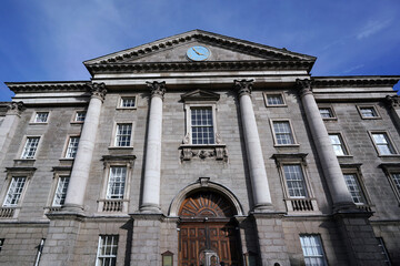 Fototapeta na wymiar Dublin, Ireland - March 2023: Trinity College, University of Dublin, facade of Regent House with front gate entrance to the old central campus.