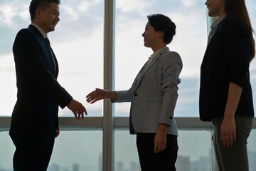 asian businesspeople shaking hands in office - obrazy, fototapety, plakaty