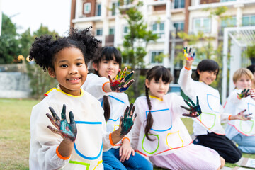 Group of student coloring on painting board outdoors in school garden. 