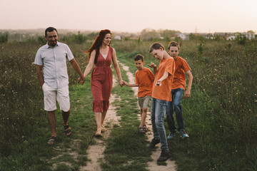 Portrait of a family in nature. Children and parents play in nature. Good time with family on vacation