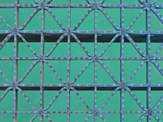 Pattern on a metal grate over blue water