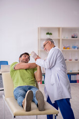 Fototapeta premium Young male patient visiting old male doctor in vaccination conce