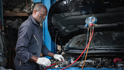Mechanics inspect and check the refrigerant and fill the car air conditioner in the garage.