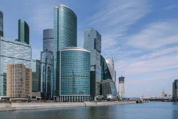 Obraz premium View of Skyscrapers of Moscow City district and pedestrian Bridge Bagration across the river in sunny day. Moscow. Russia