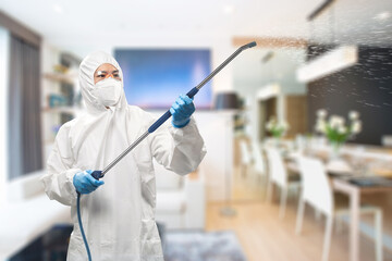 Worker wears medical protective suit or coverall suit sanitize with spray