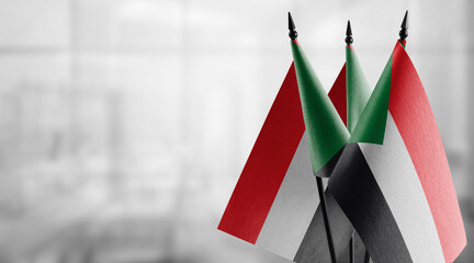 Small flags of the Sudan on an abstract blurry background