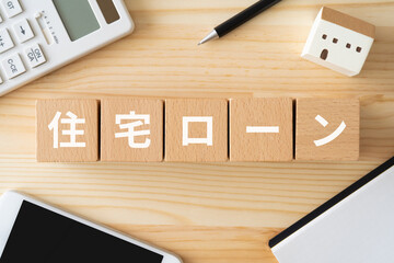 住宅ローンと書かれたブロック、電卓、家の模型、スマホ、ノート