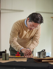 안경을 쓴 남성 재단사의 일하는 모습