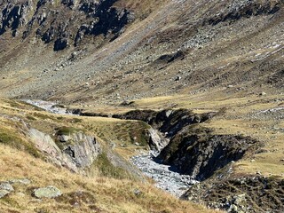 Mountain stream Aua da Grialetsch in the beautiful autumn setting of the alpine valley Val Grialetsch of the Albula Alps massif, Zernez - Canton of Grisons, Switzerland (Kanton Graubünden, Schweiz)