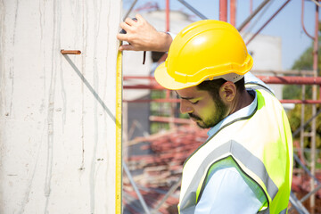 Engineer young man using tape measure for check and examining length of structure with professional at construction site, architect inspection and improvement infrastructure, industry concept.