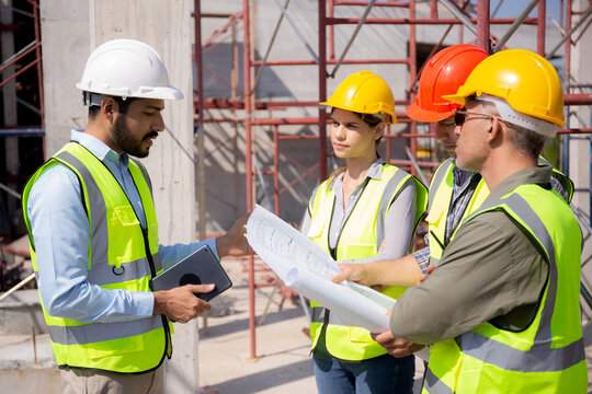 Team group of contractor and architect with foreman explaining about scheme building site for planning project to worker and looking blueprint, construction site, development and structure.