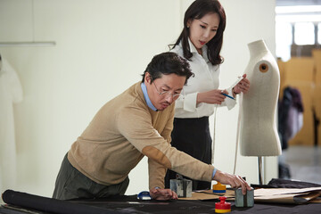 의상 디자인실에서 협업하는 디자이너와 재단사