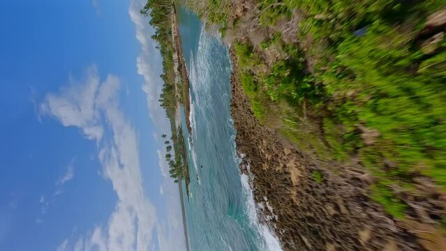 Vertical Fpv flight over tropical Islands wit waving Caribbean sea and palm trees during summer - PLAYA LOS COQUITOS, Dominican Republic 