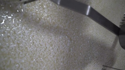 Curd and whey mixing in tank at cheese factory, close-up.