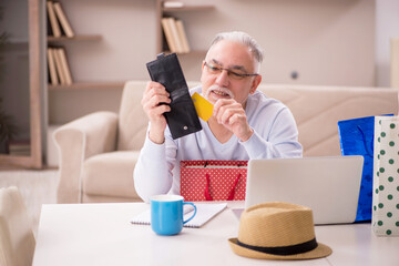Old man with many bags in Christmas concept at home