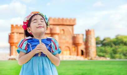 asian girls with princess dress with fairy tale castle on background. Asian kids with princess costume happy action as dreaming on classic castle background