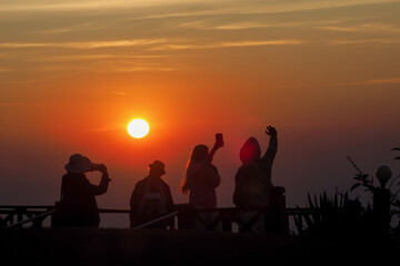 Fototapeta na wymiar asians travel relax in the holiday.People stand looking at the sun in the morning. Stand up for sunrise on the Moutain