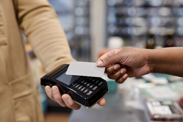 Close up of unrecognizable black woman paying via NFC and holding credit card mockup in supermarket, copy space