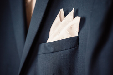 Groom in black tuxedo and bowtie correct his buttons on white shirt. Wedding. Details suit