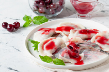 Hot dessert. Cherry dumplings with sweet sauce. Vegetarian food.