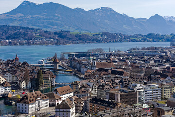Fototapeta na wymiar Aerial view of famous Swiss City of Luzern with Reuss River, Chapel Bridge, Lake Lucerne and Swiss Alps on a sunny spring day. Photo taken March 22nd, 2023, Lucerne, Switzerland.