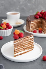 Layered honey chocolate cake with glaze and fresh raspberries on top. Delicious chocolate cake.