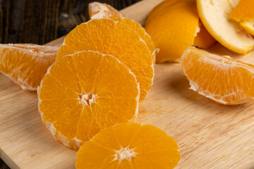 Peeled orange divided into slices on a board