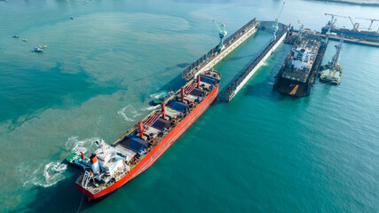 Tug boat Draging cargo container ship to dry dock concept maintenance service working in the sea....