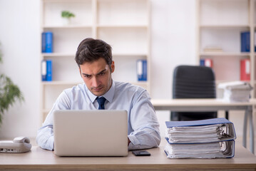 Obraz premium Young male employee working in the office