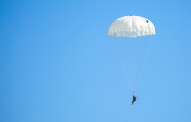 Skydiving. Flying parachutists against the background of the blue sky and mountains. Extreme sport and entertainment.