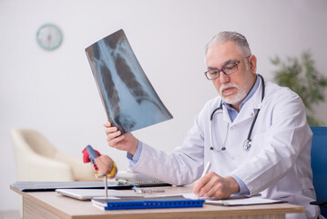 Old male doctor radiologist working at the hospital