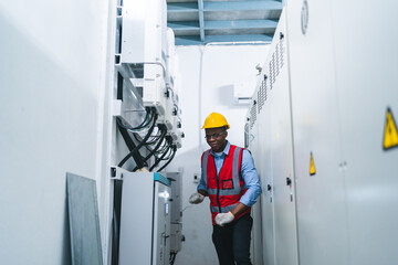 African American workers man ate work in electronic control room, machine technicians are profession inspect the factory electrical equipment, Industrial plant engineers plan to maintenance a system