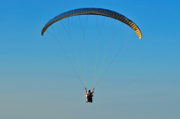 steam glider flying against the blue sky at sunset