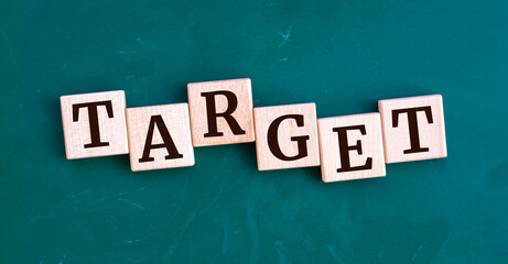 Target message sign on a wooden cubes on chalkboard background. Business concept
