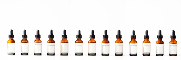 Many dropper bottles with pipette and moke up label on white background with shadow. Beauty Cometic banner of product, serum, oil for skin care.