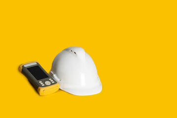 Modern gps field controler and Surveyor helmet on yellow background.