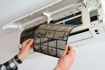 Air conditioner filter dusty. Preparation for maintenance and cleaning.