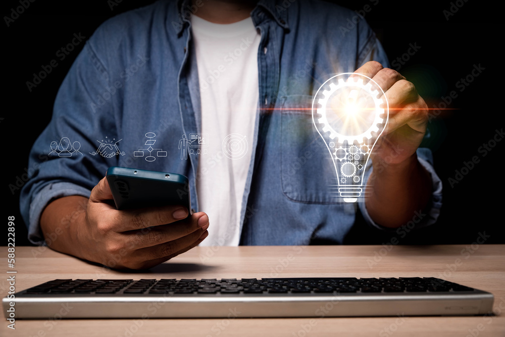 Aufkleber hand of a man with a light bulb And there is a gear icon in it And he is using smartphone and computer. The idea of inspiration from online technology. innovation idea concept
