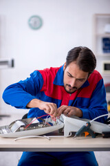 Obraz premium Young male repairman repairing heater