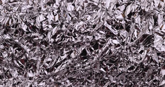 move old used crumpled aluminum foil, close-up of a foil structure with crumbs from food