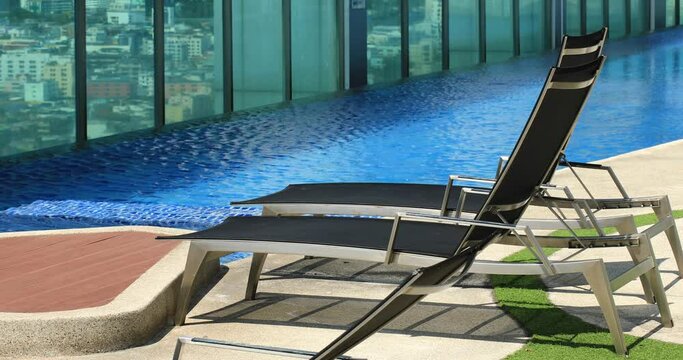 Deck Chairs Next to an Infinity Rooftop Swimming Pool in Bangkok, Thailand.