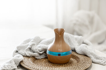 Aroma oil diffuser lamp on a blurred background.