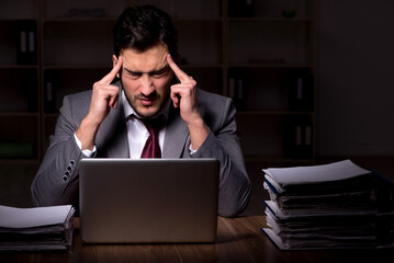 Young male employee working late in the office