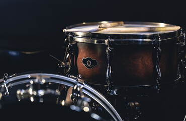 Snare drum on a blurred dark background, part of a drum kit.