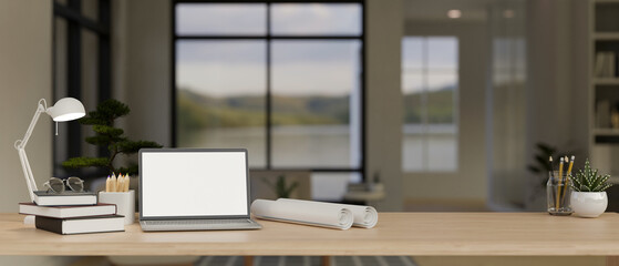 Close-up workspace with laptop mockup, roll of blueprints and decor in modern room.