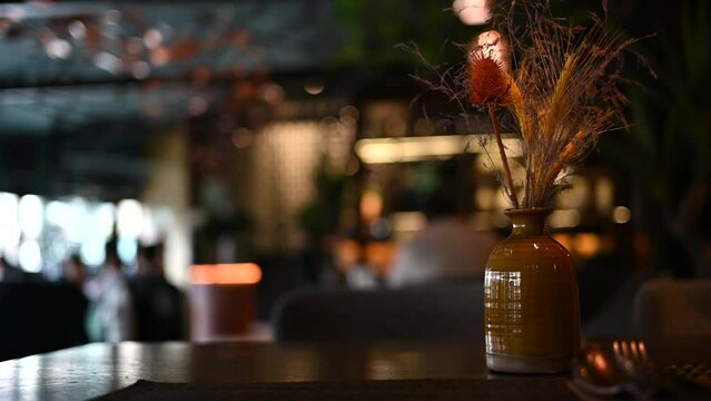 Empty table at a dark restaurant with flowers