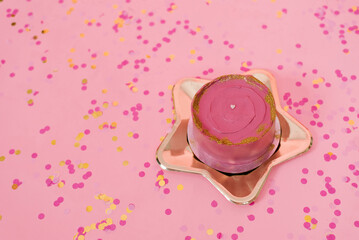 Trendy pink bento cake for Mom's day, birthday, Valentine's Day on a golden plate in the shape of a star on a pink background with confetti