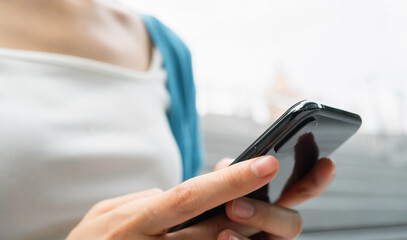 Woman using smartphone in public areas, During leisure time. The concept of using the phone is essential in everyday life.