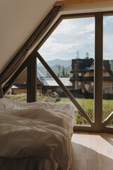 Countryside villa with picturesque view. Cozy bedroom with bed, white bed linens. Modern home interior design