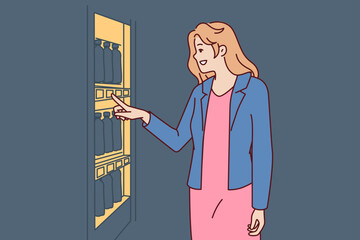 Woman stands near vending machine choosing snack or drink to buy and satisfy hunger and thirst. Young happy girl wishes to buy soda or sandwich in vending machine or automated store 